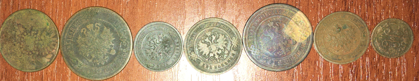 7 старинных металлических монет лежат на столе